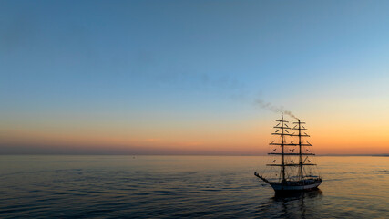 bonito atardecer en el mar junto a un barco velero
