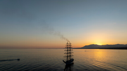 bonito atardecer en el mar junto a un barco velero