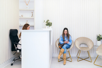 Aesthetician sharing a joyful moment with a client in a serene clinic setting, with patient...