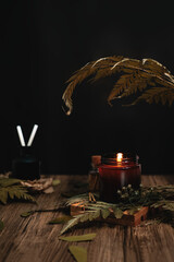 Lit aromatherapy candle with tropical vibes and leaves giving a calm and relaxing feeling