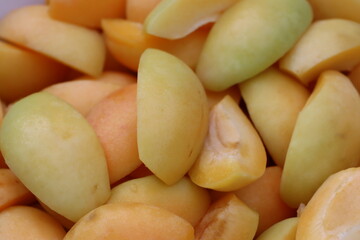 Cut into four pieces, ripe yellow apricots lie in a plate