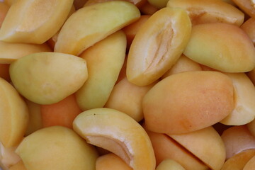 Cut into four pieces, ripe yellow apricots lie in a plate