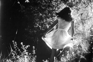 Photo argentique noir et blanc d'une fille courant dans la campagne
