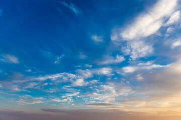Cumulostratus, Stratus and Altocumulus clouds at golden hour in the blue sky lit by the sun at...