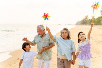 Happy Asian family travel ocean on summer holiday vacation. Grandparents and grandchildren boy and...