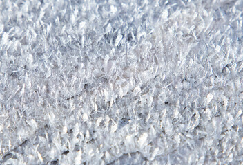 A macro shot with a layer of snow on the surface. Close-up with snowflake crystals