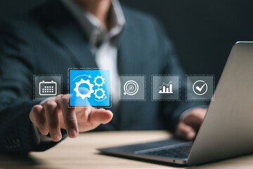 Naklejka premium Automation concept. Businessman use laptop with virtual operations management technology related to business processes and workflows, high performance, monitoring and evaluation.