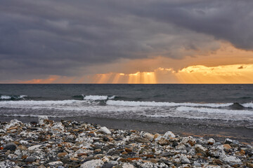 amanecer con nubes de tormenta en una playa turística del mediterráneo 
