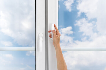 Cropped view on female hand hold handle and open pvc window to ventilate room