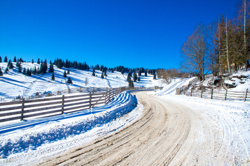 Landscape from the road in a mountain village in Bucovina, Moldavia - Romania in winter.A beautiful rural area in Romania covered with snow seen from the road
