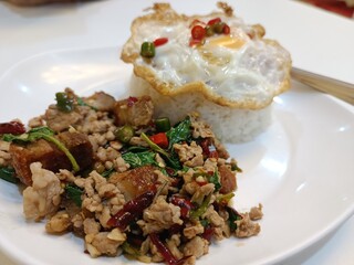 Stir-fried minced pork with basil and crispy pork on rice with fried egg