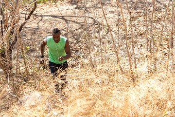 African man runner jogging and running trail in the meadow forest . Male guy running and exercising outdoors. Healthy and Sport Concept