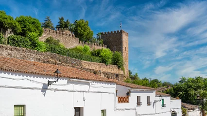 Papier Peint photo autocollant Cerro Torre Torreón y muralla almenada del alcázar templario sobre las casas blancas de la villa de Jerez de los Caballeros, España