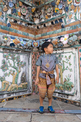 Little asiab boy wear traditional Thai suit travel in temple of dawn Wat arun