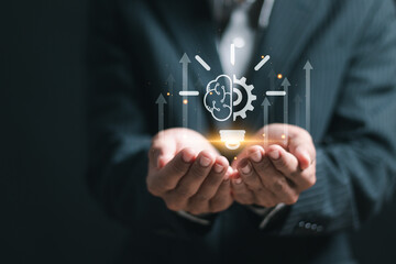 Innovation concept. Businessman holding virtual light bulb icon for creative idea.
