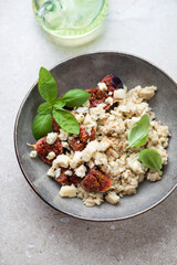 Grey plate with fig fruits and blue cheese risotto, vertical shot on a beige stone background, selective focus