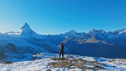 Panoramic landscape of Young man backpacker take a photo by camera at Switzerland mountain peak...