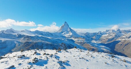 Fototapeta na wymiar Majestic mountain peaks full of stacked rock hiker cairns with famous Matterhorn view background during winter in Switzerland. Swiss alps wonderful inspiring nature landscape.