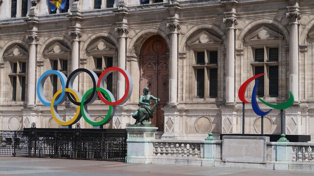 JO de Paris 2024, anneaux olympiques, c&eacute;l&egrave;bre logo symbole des jeux olympiques, et agitos embl&egrave;me des jeux paralympiques, devant la fa&ccedil;ade de la mairie / h&ocirc;tel de ville de Paris &ndash; mai 2023 (France)