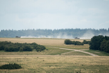 Fototapeta na wymiar camouflage military vehicle in motion through countryside