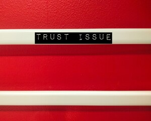 Red wall with handwriting text TRUST ISSUE, haveing extremely difficult time trusting others who mistreated you or let you down— fear of betrayal or abandonment