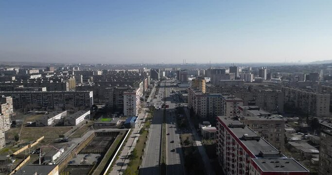 Drone above post soviet city in Georgia.
Slowly moving in the air between panoram of old and new buildings with light car traffic down.
