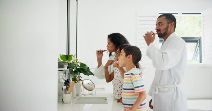 Father, teaching or children in bathroom brushing teeth together for development in morning at family home. Siblings learning, dad or kids cleaning mouth with toothbrush for dental or oral health