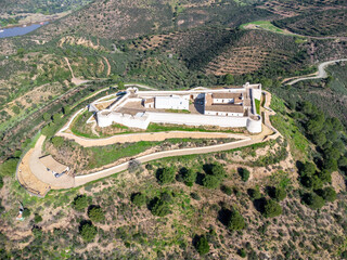 Fototapeta na wymiar Aerial drone view of San Marcos Castle in a mountain of Sanlucar de Guadiana village in Huelva province, Andalusia, on the banks of Guadiana river, in the border of spain with portugal