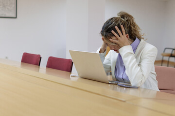 Mujer cansada con las manos en la cabeza trabajando en su oficina 