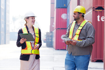 Engineer wearing safety helmet inspects containers.