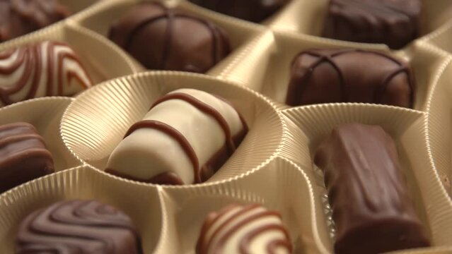 Box of assorted chocolates pralines with smooth rotation motion close up view