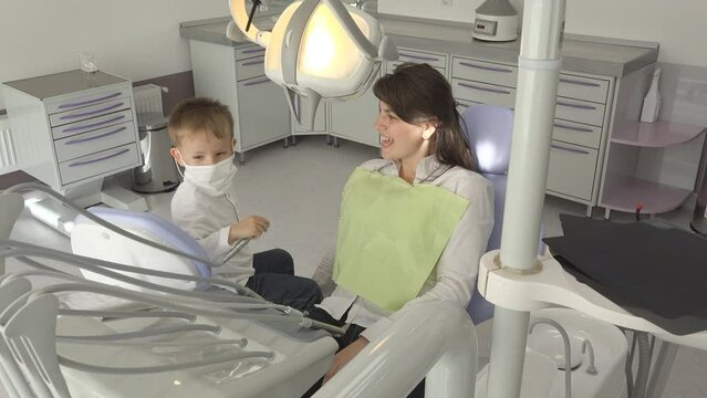 Little boy playing as dentist with his mother