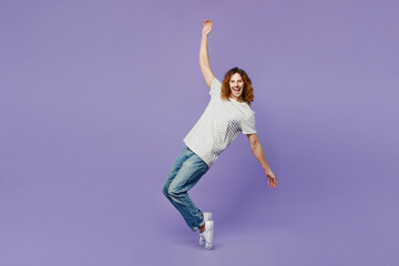 Fototapeta na wymiar Full body side view young man he wear grey striped t-shirt casual clothes stand on toes leaning back with outstretched hands isolated on plain pastel light purple background studio. Lifestyle concept