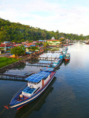 Colorful blue and red fishing boats in the Batang Arau river and port in Padang City in West Sumatra, Indonesia. - obrazy, fototapety, plakaty