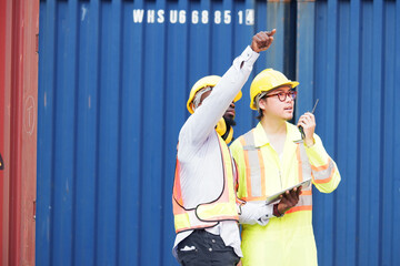 Engineer wearing safety helmet working in container warehouse.