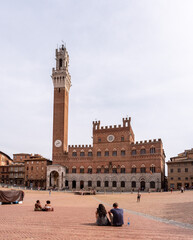 SIENA, ITALY - SEPTEMBER 23, 2023 - The iconic Palazzo Pubblico at the Piazza del Campo in downtown Siena - obrazy, fototapety, plakaty