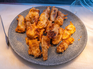 A Circular Plate Filled with Pieces of Banana Fritters