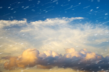 Dramatic sky with stormy clouds and snowfall.