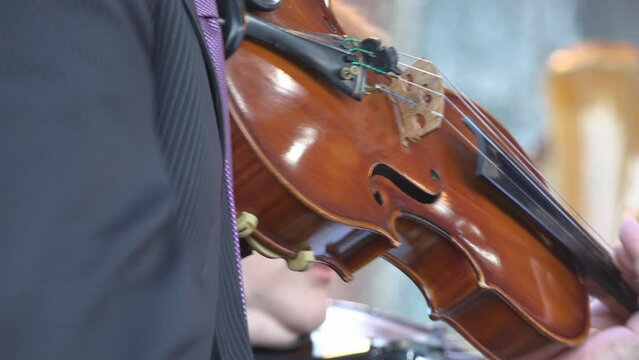 Detail of hands playing the violin in orchestra