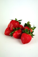 Red ripe strawberries lie on a white background