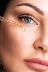 A woman or young girl drips serum, serum or hyaluronic acid from a pipette. Clean skin