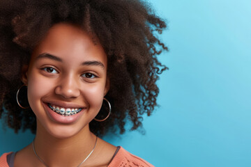 Smiling african american girl with dental braces on blue background, Orthodontic treatment, Teenager teeth correction