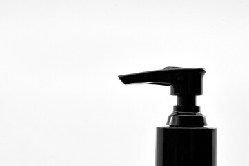 Top of a push pump liquid soap bottle in black and white isolated on a plain white background. Copy space. No people.