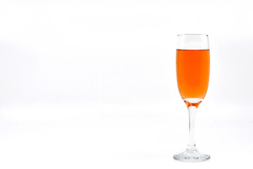 Flute glass of pink champagne isolated on a white background. Copy space to left. No people.