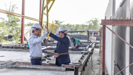 Factory owner and his engineer express a great success or achievement from their business.