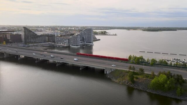 An aerial view of the Kalasatama bridge stretching over the river in the city, with the metro line running alongside, offers a captivating perspective of urban connectivity and infrastructure in actio