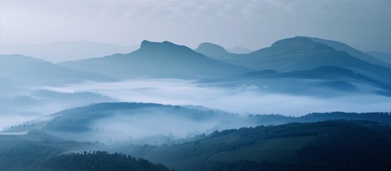 Majestic Mountains Rise Behind Serene and Foggy Hills