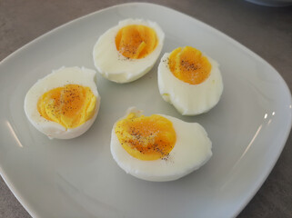 Two boiled sliced eggs arranged on a white plate