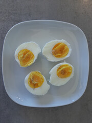 Two boiled sliced eggs arranged on a white plate