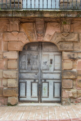 Fototapeta na wymiar Wooden door on stone facade of an 18th century house